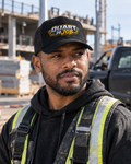 Homme noir métissé sur un chantier portant la casquette trucker noire Quart de Job